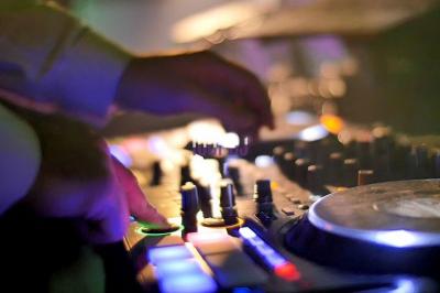 Une femme en robe blanche joue de la harpe dans une salle décorée avec des plantes et des lumières.