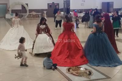 Deux mains entrelacées sur une table, avec des verres et une ambiance romantique en arrière-plan.