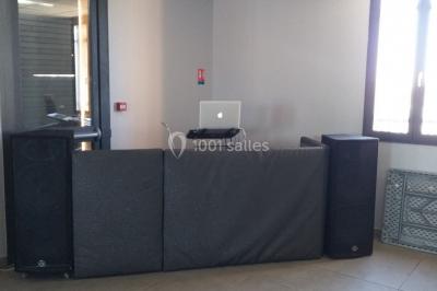 Deux mains entrelacées sur une table, avec des verres et une ambiance romantique en arrière-plan.