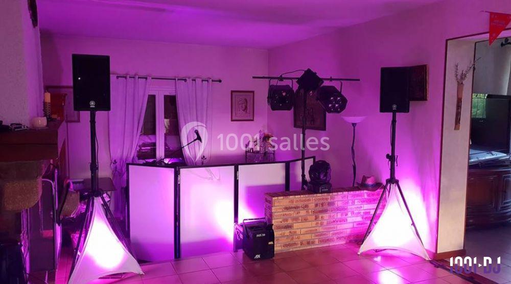 Installation de matériel de sonorisation et éclairage dans une pièce, avec une table de mixage et des projecteurs LED.