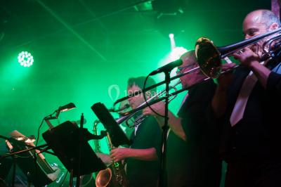 Scène de concert avec instruments et éclairages colorés dans une salle vide.