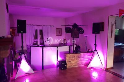 Scène de concert avec instruments et éclairages colorés dans une salle vide.