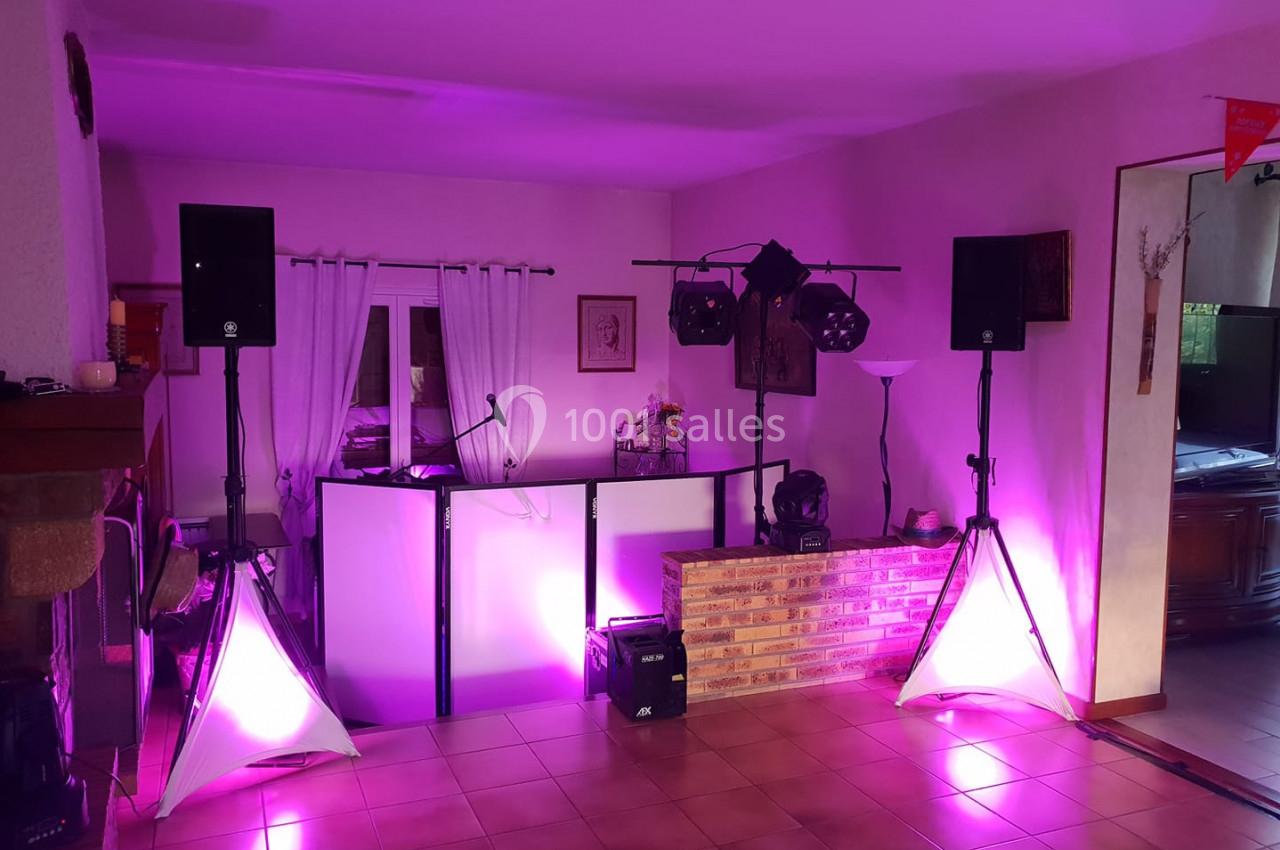 Installation de matériel de sonorisation et éclairage avec projecteurs roses dans une pièce à usage événementiel.