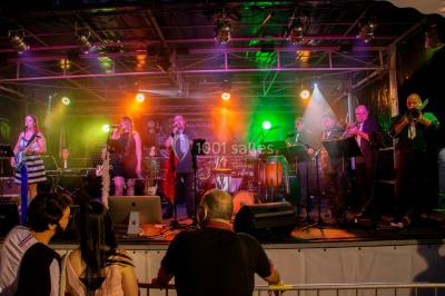 Scène de concert avec instruments et éclairages colorés dans une salle vide.