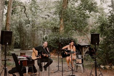 Scène de concert avec instruments et éclairages colorés dans une salle vide.