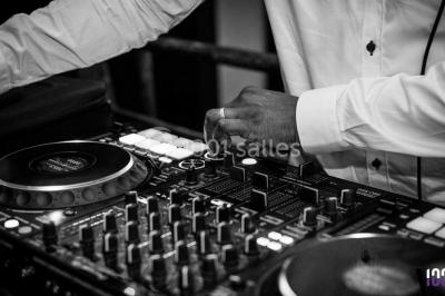 Scène équipée de matériel de sonorisation et d'éclairage, avec une table de mixage et des projecteurs bleus.