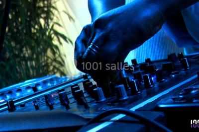 Groupe de personnes réunies en soirée en plein air, éclairées par des guirlandes lumineuses et des lampadaires.