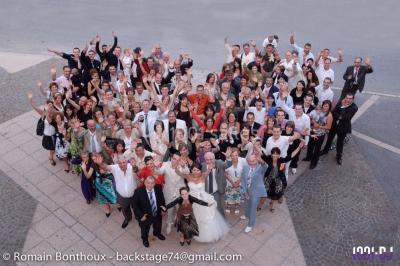 Un homme chante au micro sur une scène éclairée par des lumières bleues et violettes.