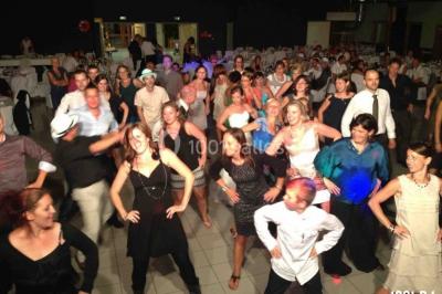 Un homme chante au micro sur une scène éclairée par des lumières bleues et violettes.