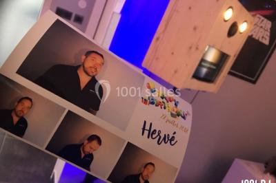 Un homme chante au micro sur une scène éclairée par des lumières bleues et violettes.