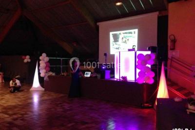 Un homme chante au micro sur une scène éclairée par des lumières bleues et violettes.