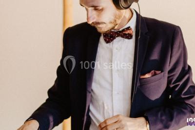 Un couple danse sur une piste éclairée par des lumières colorées, entouré de spectateurs dans une salle festive.
