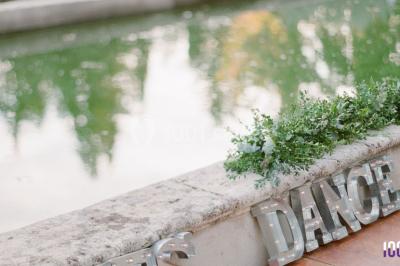 Un couple danse sur une piste éclairée par des lumières colorées, entouré de spectateurs dans une salle festive.
