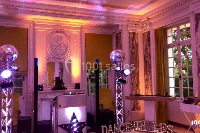 Un couple danse sur une piste éclairée par des lumières colorées, entouré de spectateurs dans une salle festive.