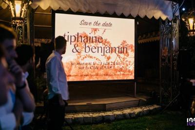 Un couple danse sur une piste éclairée par des lumières colorées, entouré de spectateurs dans une salle festive.