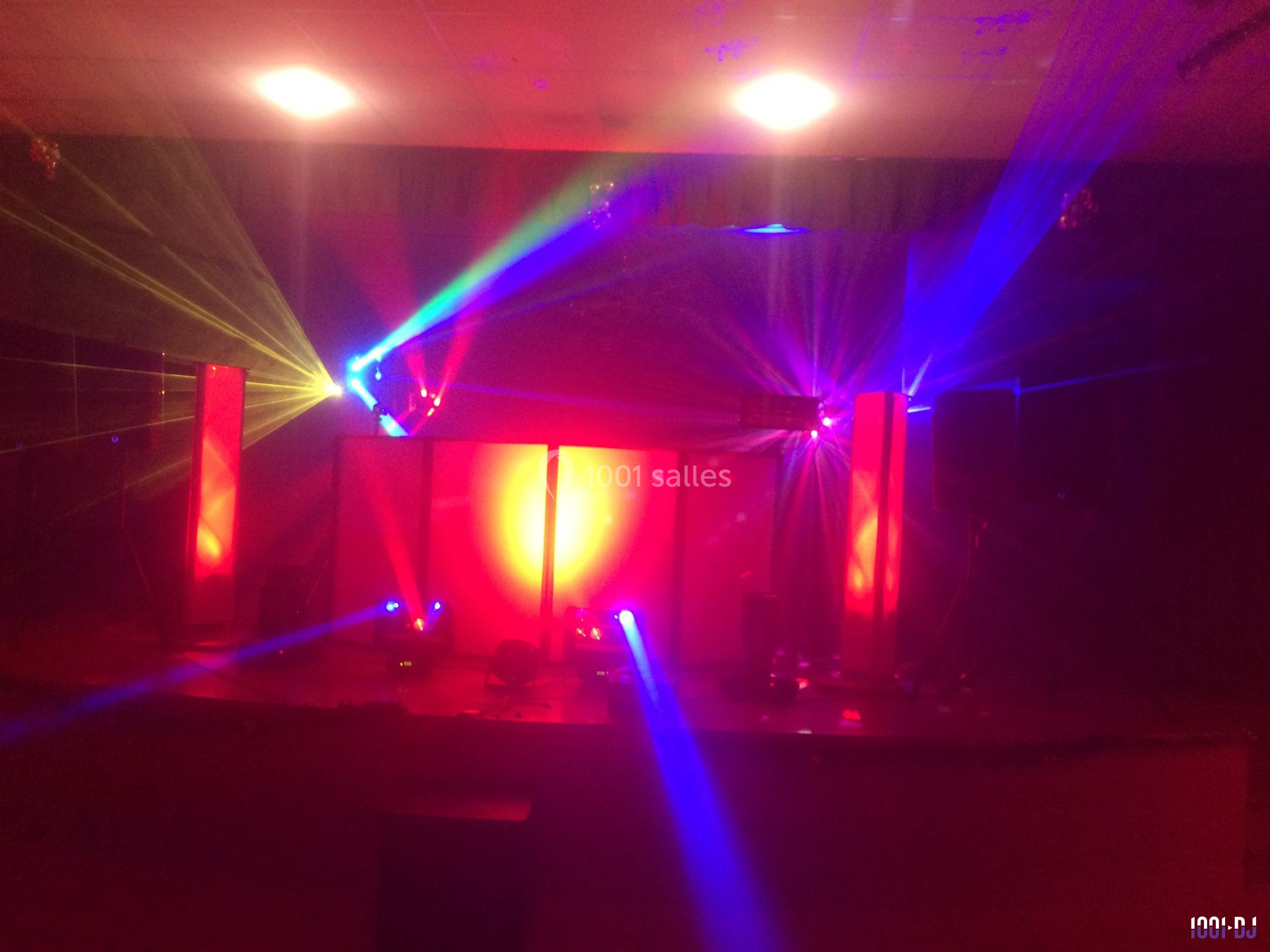 Jeu de lumières colorées projetées dans une salle sombre, créant une ambiance festive et immersive.