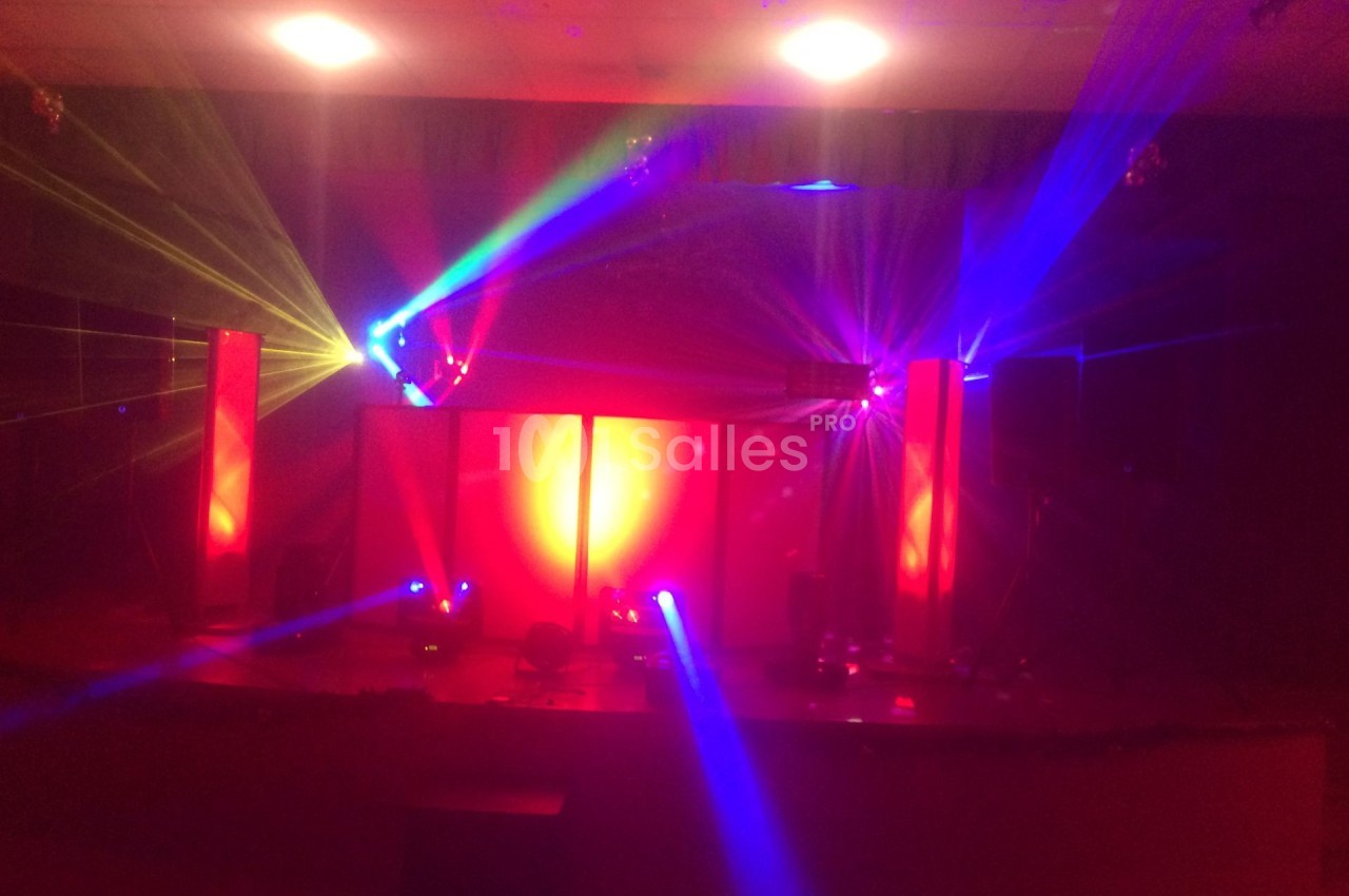 Jeu de lumières colorées projetées dans une salle sombre, créant une ambiance festive et immersive.