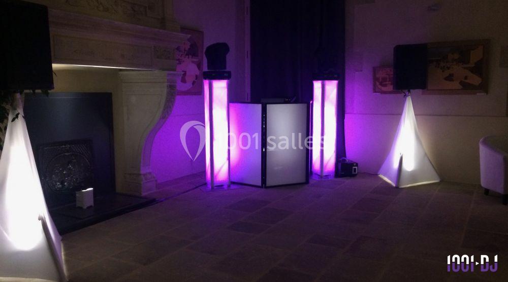 Installation de matériel de sonorisation et éclairage avec lumières violettes dans une pièce au décor classique.