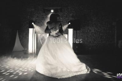 Deux hommes sur scène, l'un chante au micro tandis que l'autre pointe du doigt près d'un équipement audio.