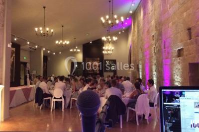 Deux hommes sur scène, l'un chante au micro tandis que l'autre pointe du doigt près d'un équipement audio.