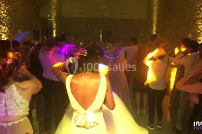 Deux hommes sur scène, l'un chante au micro tandis que l'autre pointe du doigt près d'un équipement audio.