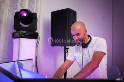 Deux hommes sur scène, l'un chante au micro tandis que l'autre pointe du doigt près d'un équipement audio.