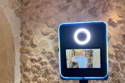 Salle décorée pour un événement avec éclairage violet, machines à fumée et équipements audio devant une baie vitrée.