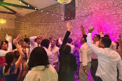 Salle décorée pour un événement avec éclairage violet, machines à fumée et équipements audio devant une baie vitrée.