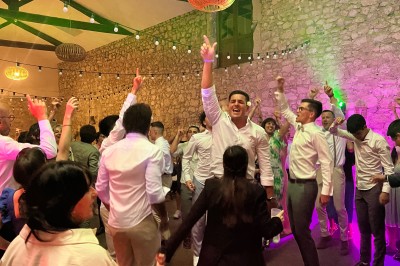 Salle décorée pour un événement avec éclairage violet, machines à fumée et équipements audio devant une baie vitrée.