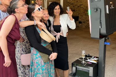 Salle décorée pour un événement avec éclairage violet, machines à fumée et équipements audio devant une baie vitrée.