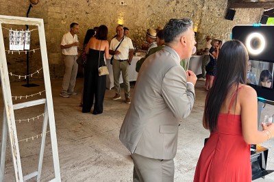 Salle décorée pour un événement avec éclairage violet, machines à fumée et équipements audio devant une baie vitrée.