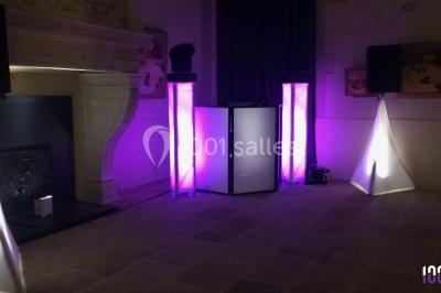 Deux hommes sur scène, l'un chante au micro tandis que l'autre pointe du doigt près d'un équipement audio.