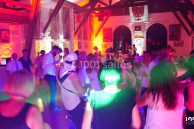 Deux hommes sur scène, l'un chante au micro tandis que l'autre pointe du doigt près d'un équipement audio.