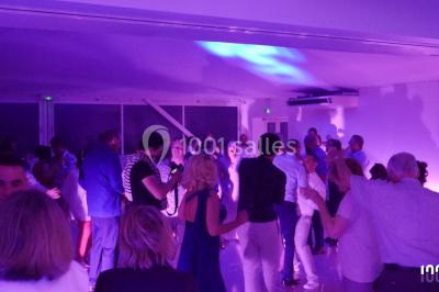 Deux hommes sur scène, l'un chante au micro tandis que l'autre pointe du doigt près d'un équipement audio.