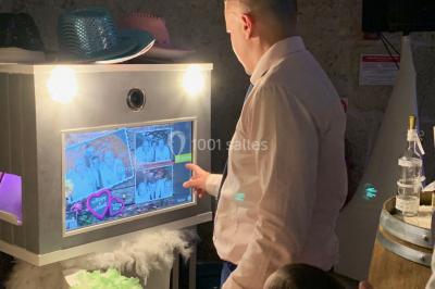 Deux hommes sur scène, l'un chante au micro tandis que l'autre pointe du doigt près d'un équipement audio.