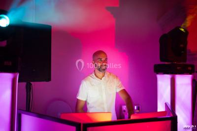 Deux hommes sur scène, l'un chante au micro tandis que l'autre pointe du doigt près d'un équipement audio.