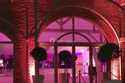 Scène de concert avec batterie, guitares, claviers et micros sous un éclairage coloré.