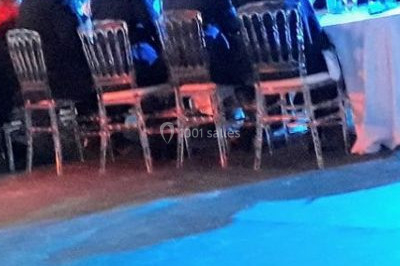 Scène de concert avec batterie, guitares, claviers et micros sous un éclairage coloré.