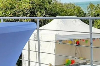 Scène de concert avec batterie, guitares, claviers et micros sous un éclairage coloré.