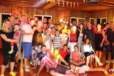 Un DJ mixant de la musique sur une table de mixage éclairée par des lumières colorées dans une ambiance nocturne.