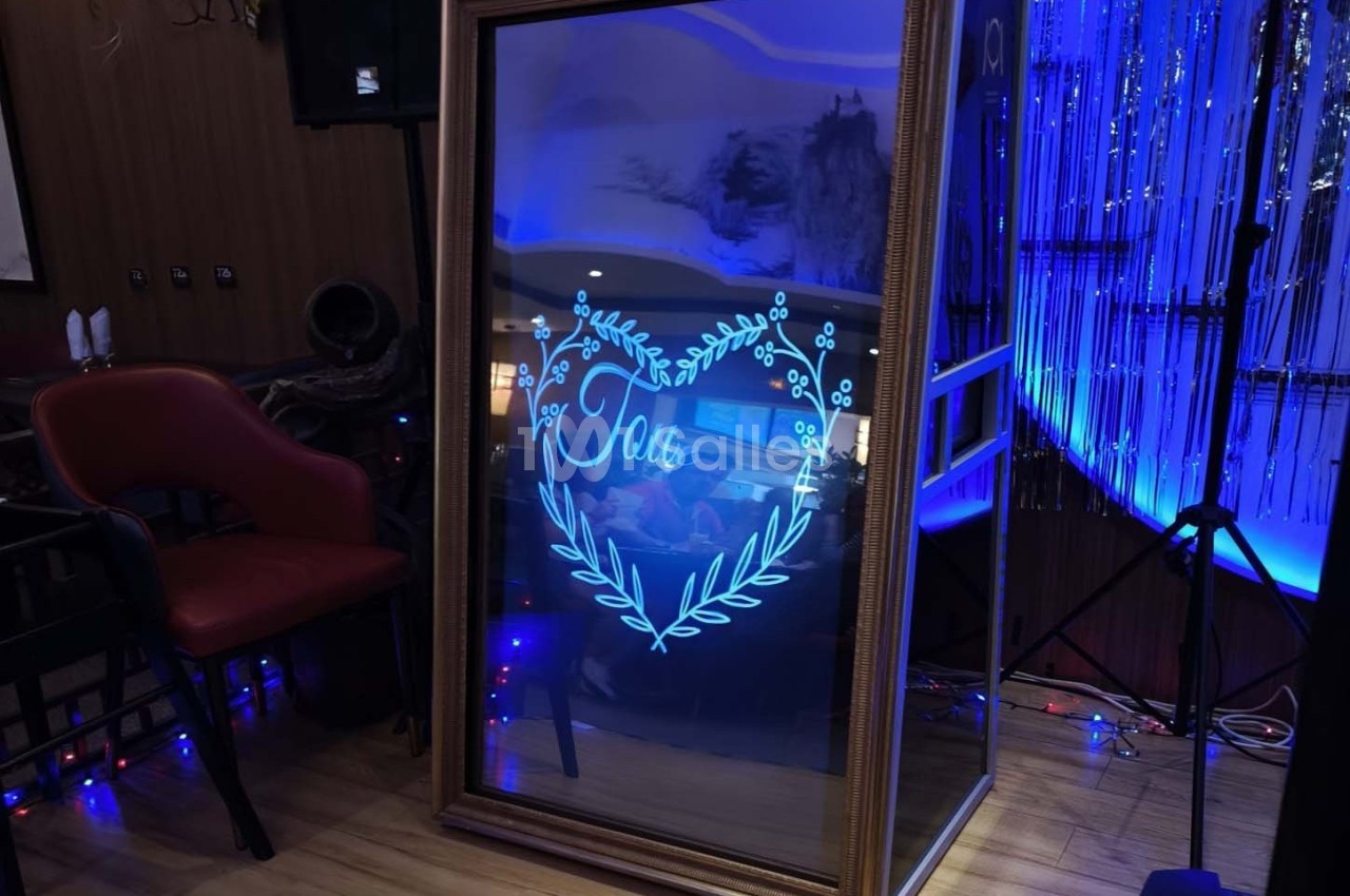 Miroir interactif encadré affichant un cœur lumineux avec le mot ’Love’, dans un décor intérieur éclairé en bleu.