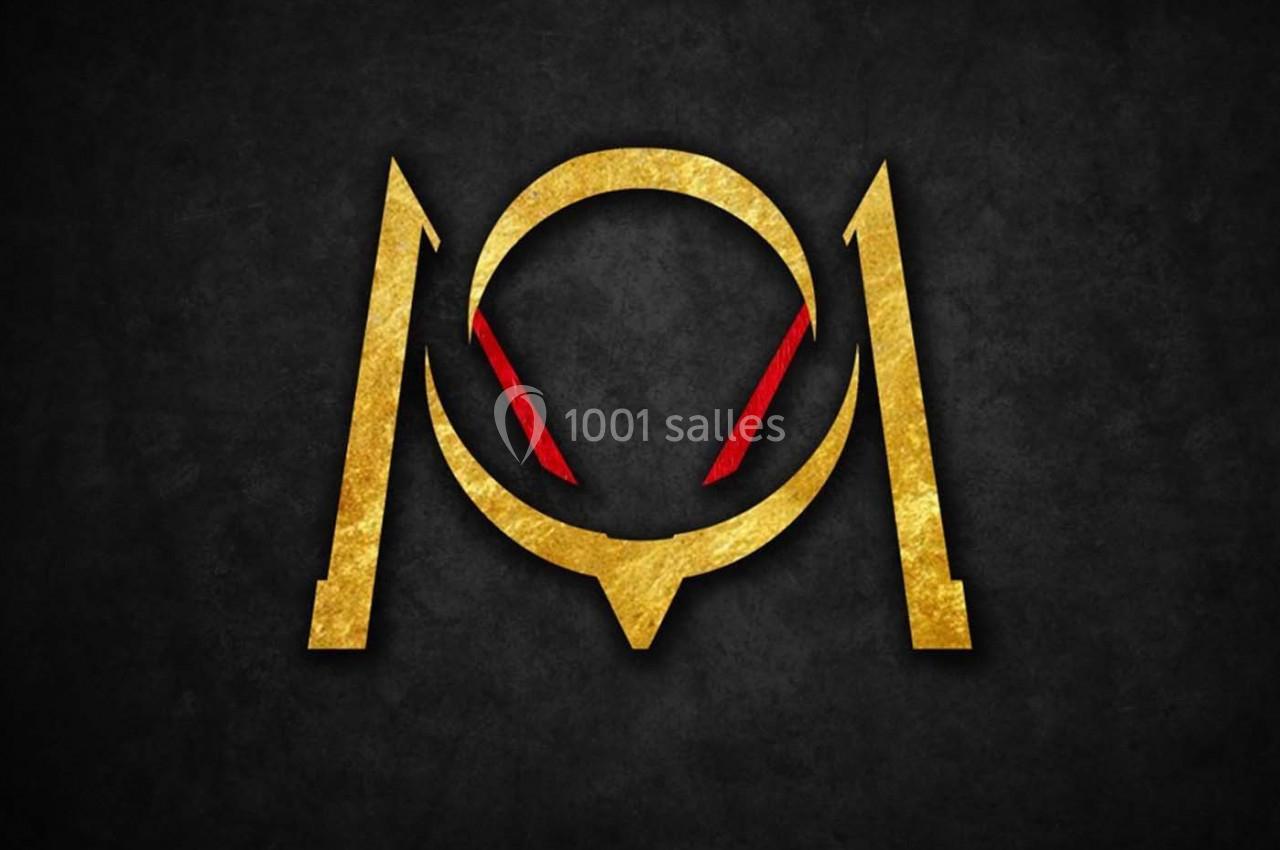 Logo doré stylisé avec des formes géométriques et des accents rouges sur un fond noir texturé.