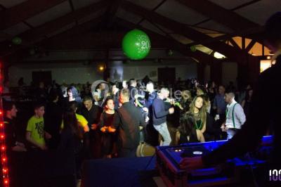 Salle de réception en plein air sous une verrière, avec tables décorées, nappes blanches et éclairage chaleureux.