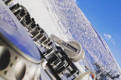 Salle de réception en plein air sous une verrière, avec tables décorées, nappes blanches et éclairage chaleureux.