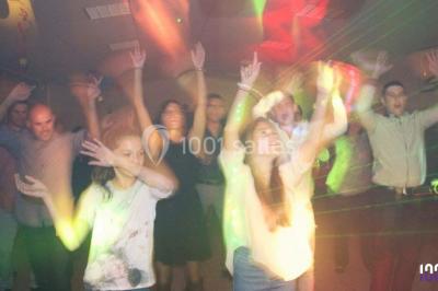 Table de mixage DJ avec platines lumineuses et un ordinateur portable affichant un logiciel de mixage.