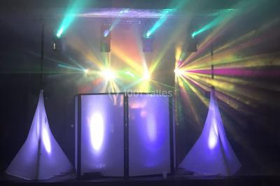 Table de mixage DJ avec platines lumineuses et un ordinateur portable affichant un logiciel de mixage.