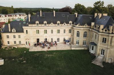 Console de DJ éclairée en bleu et rouge, installée dans une salle vitrée avec des invités en arrière-plan.