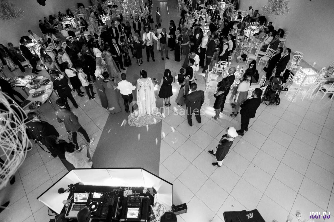 Vue aérienne en noir et blanc d'une réception de mariage avec des invités rassemblés autour des mariés.