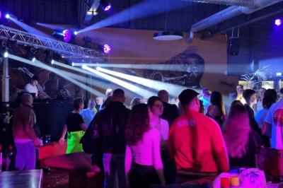 Homme portant un casque audio, vu de profil, concentré dans un environnement sombre en noir et blanc.