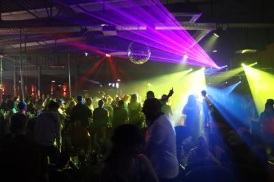 Homme portant un casque audio, vu de profil, concentré dans un environnement sombre en noir et blanc.